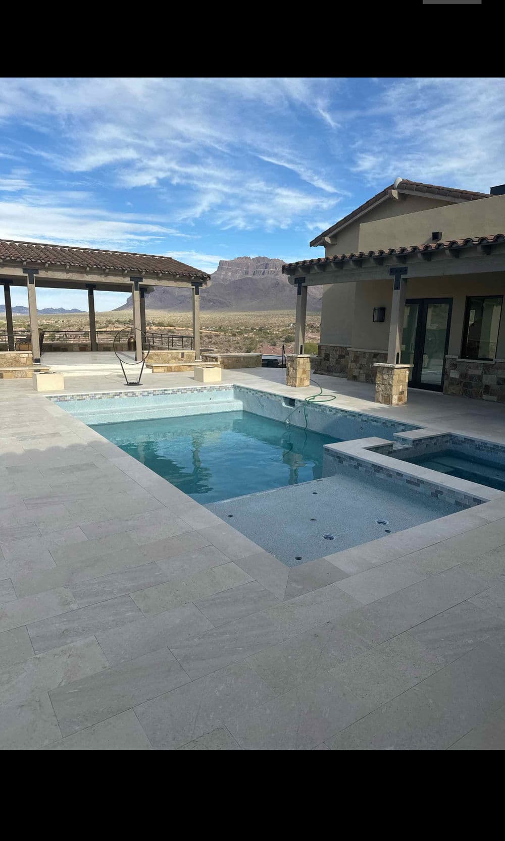 Luxury modern home with a pool and spa overlooking scenic mountain views.
