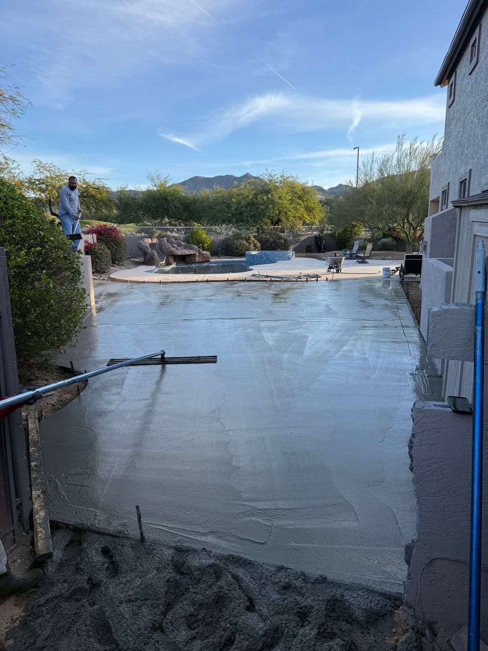 Concrete being poured for a residential driveway with mountains in the background.